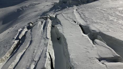 Empuje-Aéreo:-Paisaje-Invernal-En-Los-Alpes,-Grietas-Hechas-Agujeros-En-La-Nieve