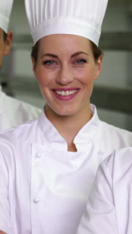 four cheerful chefs looking at camera with arms crossed