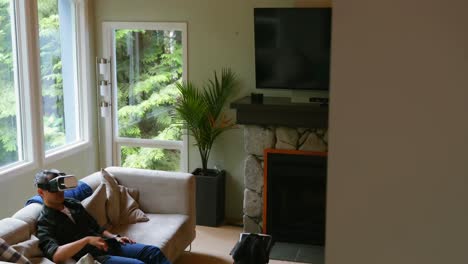 father and son using virtual reality headset in living room 4k