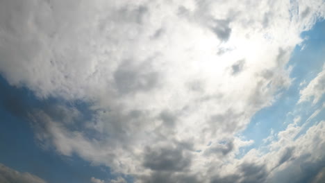 Sun in the sky is slowly covered with light grey cloudscape. Dramatic clouds overcastting the horizon. Low angle view. Timelapse.