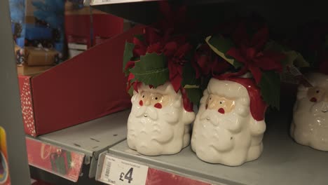 Poinsettia-Floral-Arrangement-In-Ceramic-Santa-Pots-Displayed-In-The-Shelf