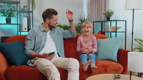 daughter child kid tells an interesting funny secret story or joke to father, enjoying friendship