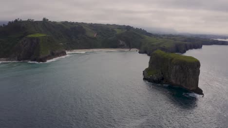 Aerial-Rising-Over-Ballota-Beach-And-Castro-Ballota-Island-Scenery,-Spain