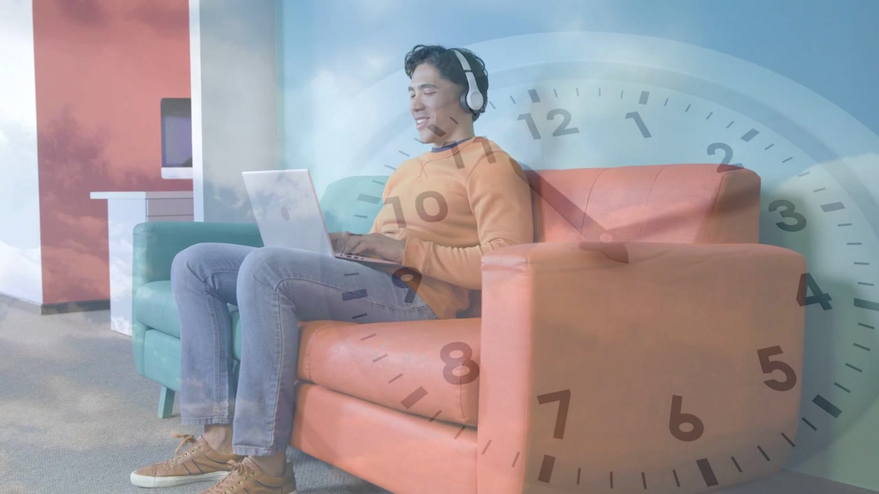 Man starting typing on laptop in lounge, causing clock cloud overlay fading while studying