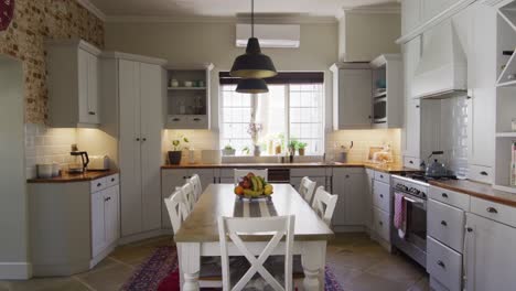 general view of kitchen interior with cupboards, countertop and table