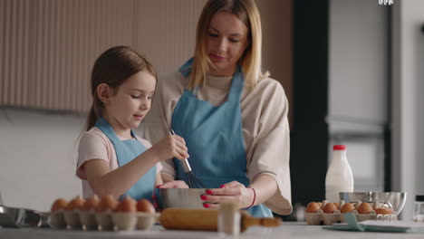 Una-Mujer-Adulta-Está-Enseñando-A-Una-Niña-A-Cocinar,-Madre-E-Hija-Están-Mezclando-Masa-Para-Panqueques-O-Pizza