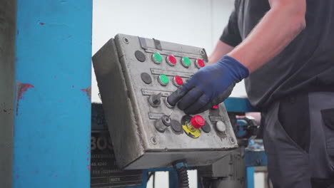 trabajador de almacén industrial operando maquinaria pesada con controles