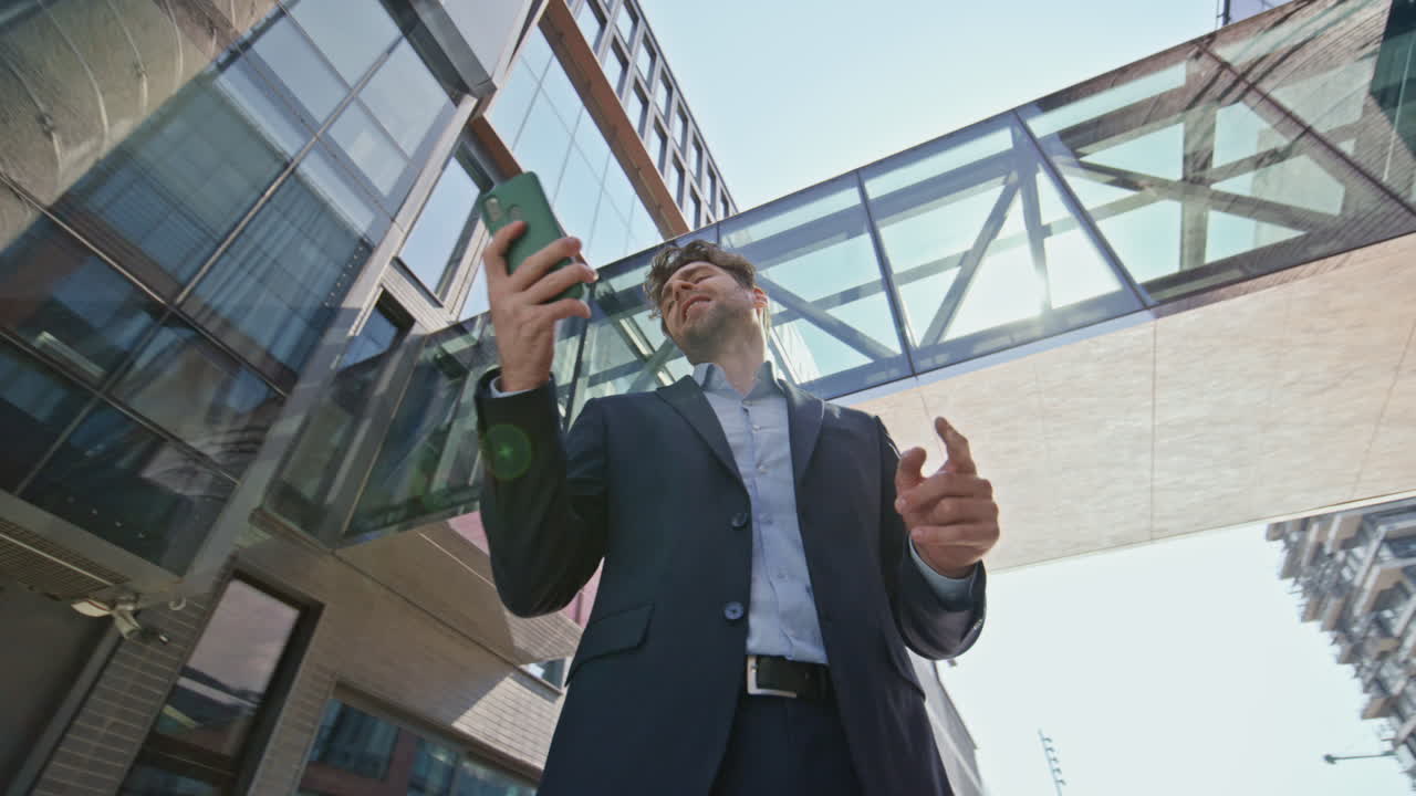 길거리에서 휴대 전화 통화를 하는 사업가. 짜증 난 상사가 대화를 끝니다.