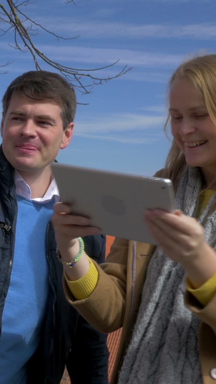 Couple taking a selfie with a tablet outdoors