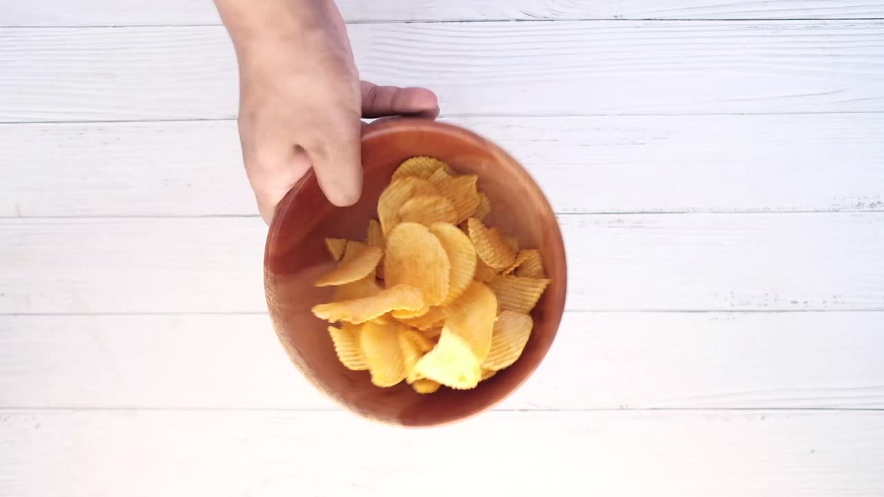 Hand Holding a Bowl of Potato Chips