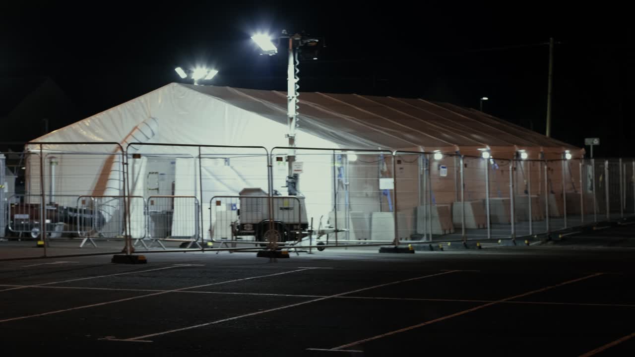 Handheld COVID Test Centre Tent at night with lights beaming at the tent