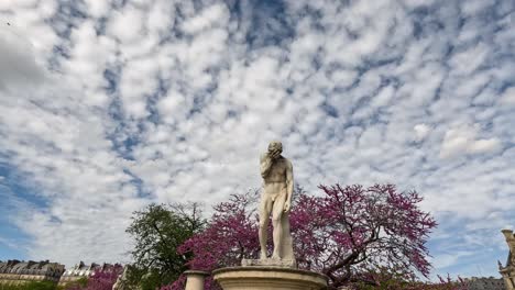 estatua con árboles en flor y cielo nublado