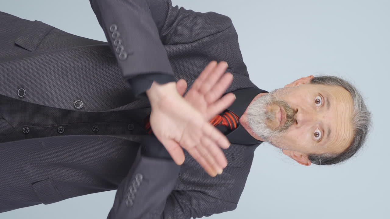 ⁇ 은 사업가의 수직 비디오가 엄격한 표정으로 카메라를 경고합니다.