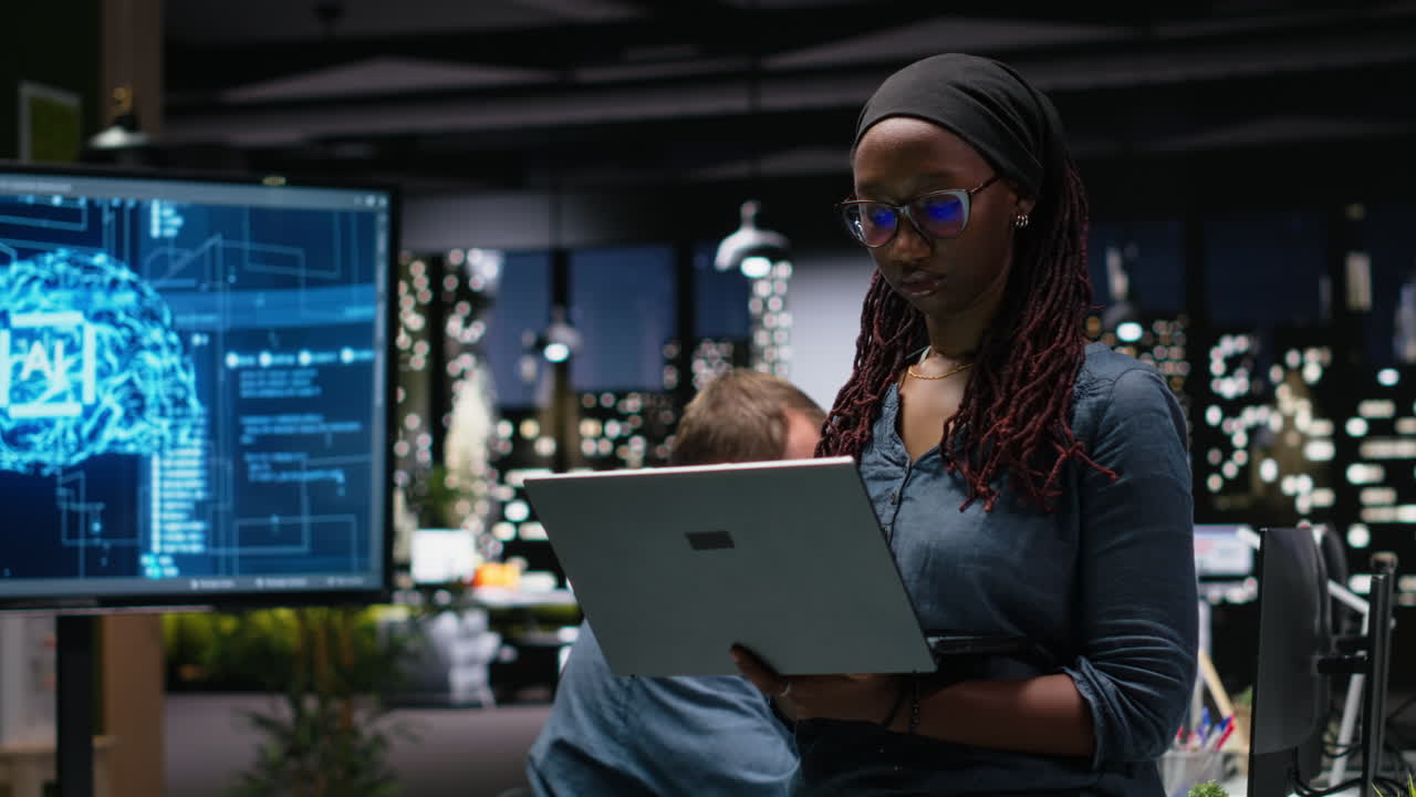 Focused African American Woman Working on Laptop in Modern Tech Office