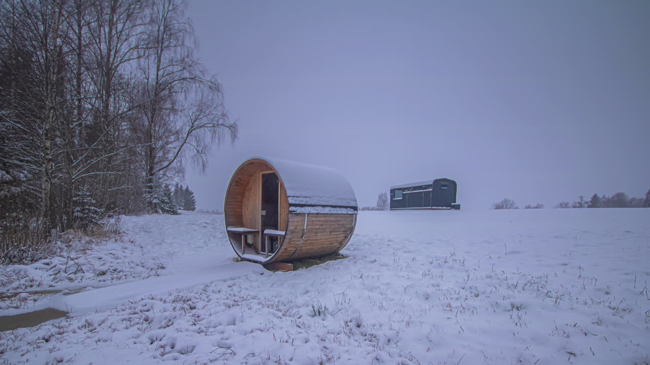 Timelapse multistaagionale che mostra primavera, estate, autunno e inverno e la costruzione di un sentiero pedonale verso una lussuosa capanna sauna nel bosco