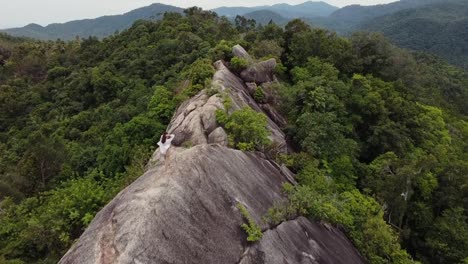 Junge-Frau-Balanciert-Sich-Auf-Einer-Großen-Klippe-Mit-Blick-Auf-Den-Dschungel