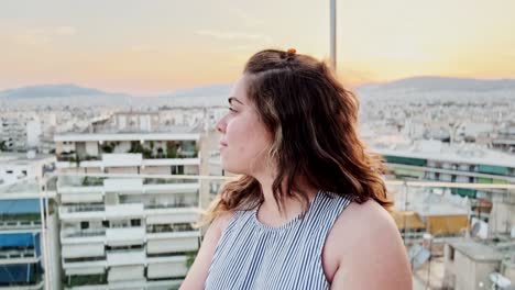 vlogger capturing athens rooftop sunset with outstretched arm