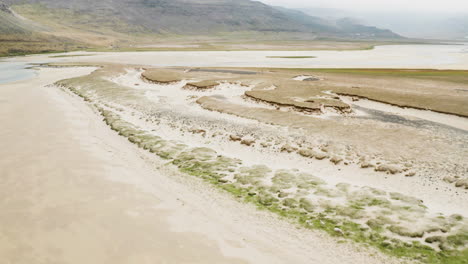 dolly aéreo en toma de dunas increíbles y un lago en westfjords en irlanda