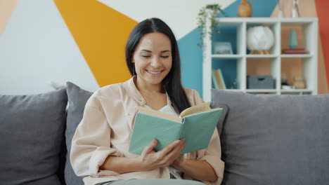 mujer leyendo un libro en un sofá