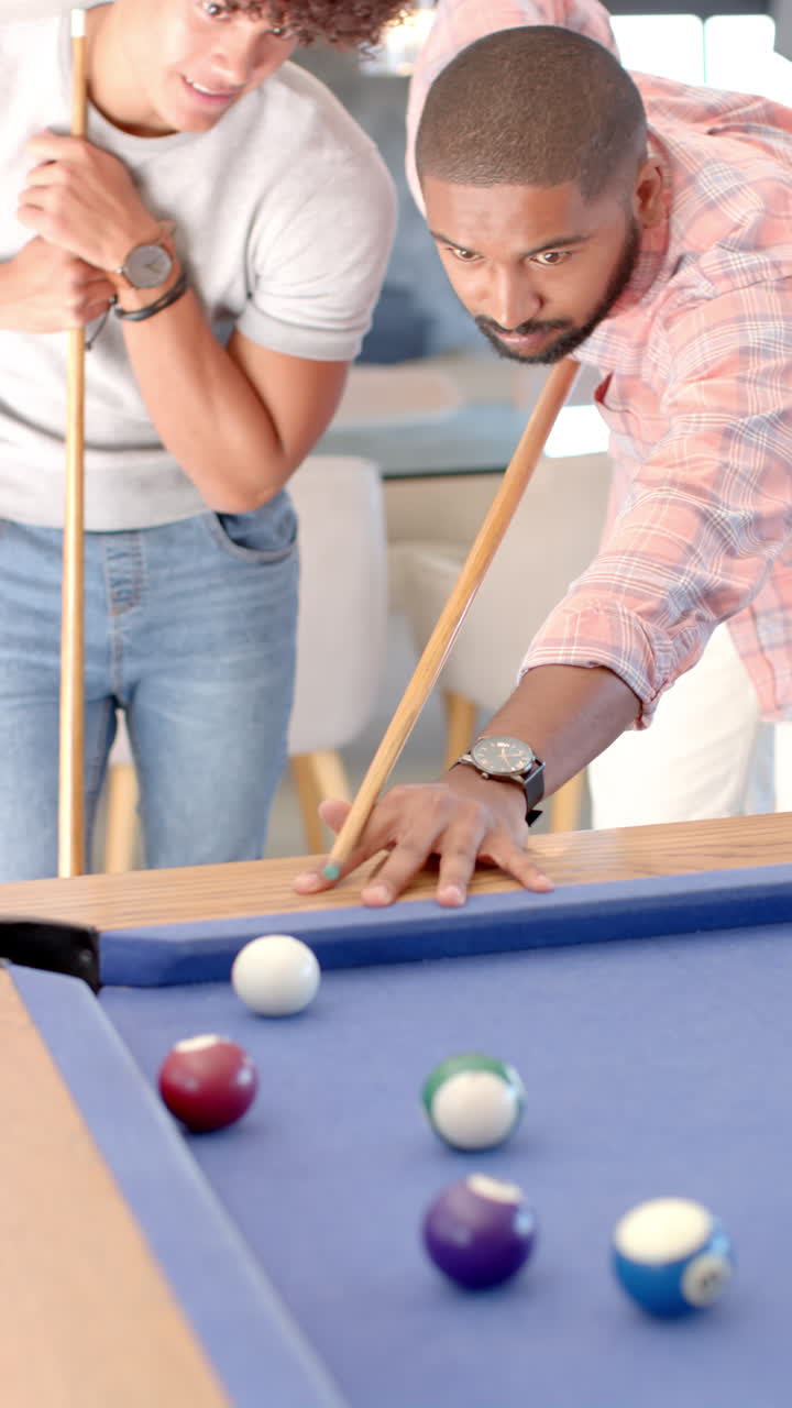 Vertical video: Playing pool, friends enjoying game together in bar and having fun