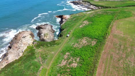 the rugged coastline near foz, galicia, with waves crashing against cliffs, aerial view