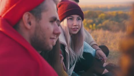 girl-spends-time-with-friends-at-burning-bonfire-in-evening