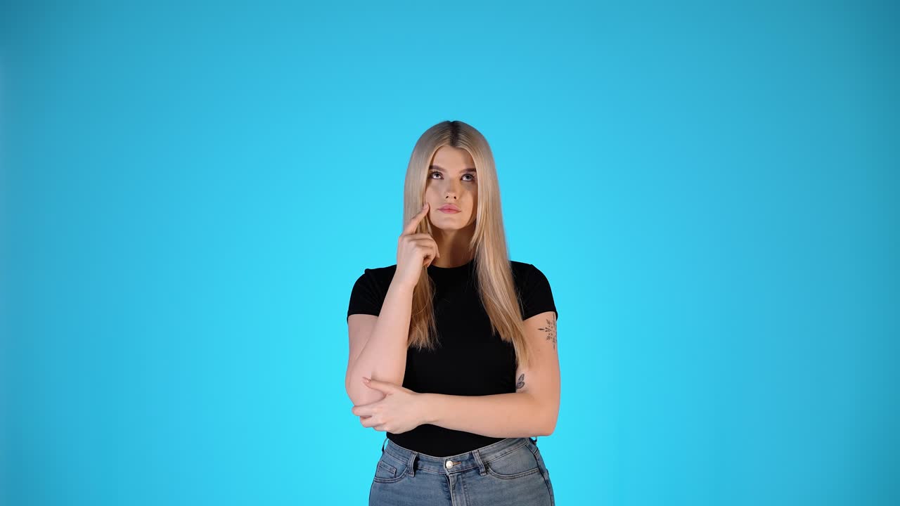 retrato de una hermosa mujer rubia pensando, pensativa dudosa incierta con el gesto de los brazos, toma de estudio