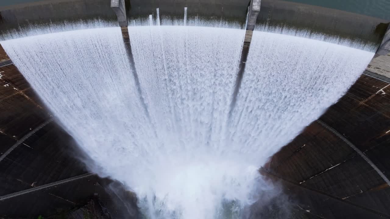 Vista dall'alto del bacino idrico di Encoro do Eume in Galizia, Spagna - Diga in cemento con acqua che straripa dallo sfioratore. Ripresa aerea ascendente