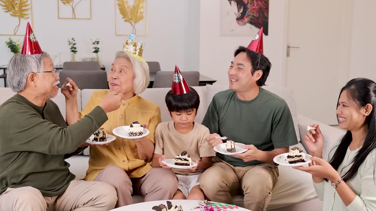 A joyful family of three generations shares cake in a festive, warmly lit living room
