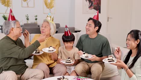 a joyful family of three generations shares cake in a festive, warmly lit living room