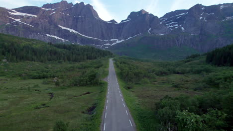 aerial shot of a camper van driving on the scenic road to nusfjord in lofoten island, norway
