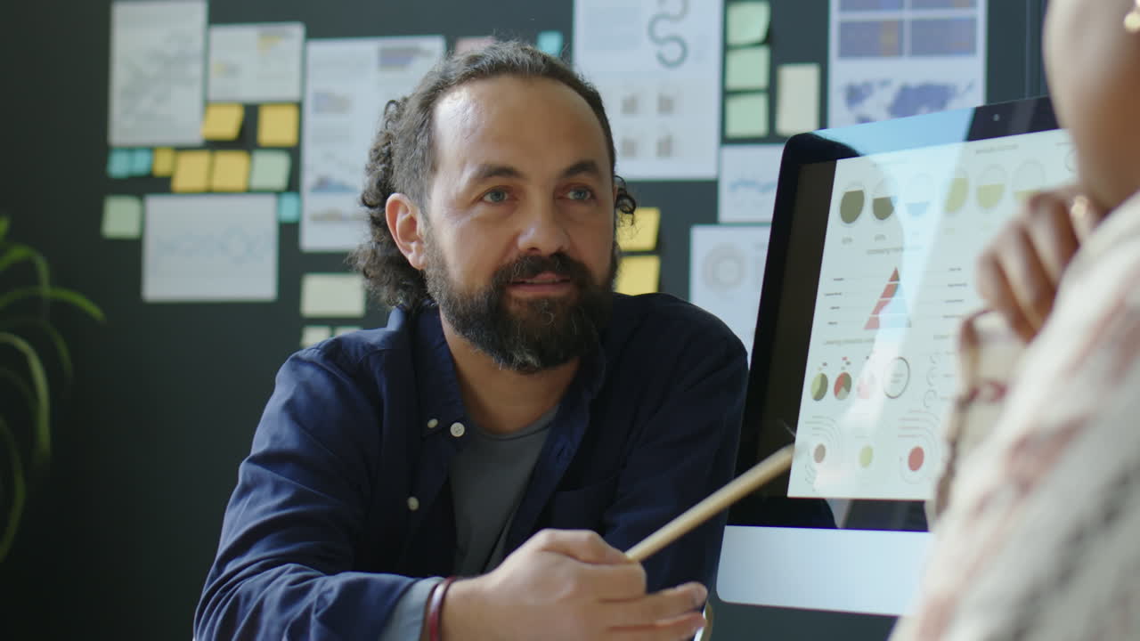 Businessman Discussing Financial Graphs with Team