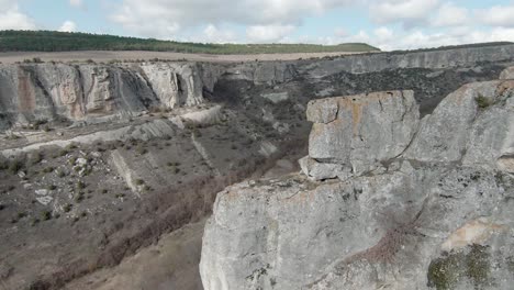 vista de ángulo alto de un cañón con acantilados rocosos y vegetación seca