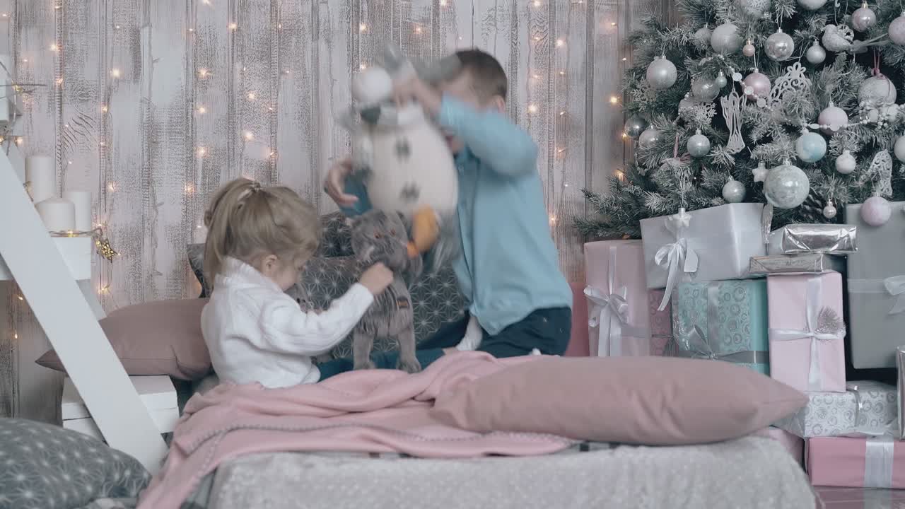 hermano pequeño y hermana juegan con juguetes en un sofá rosa