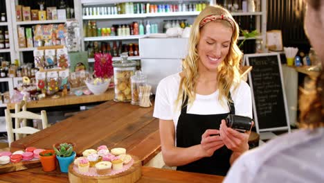 Customer-making-payment-through-payment-terminal-machine-at-counter