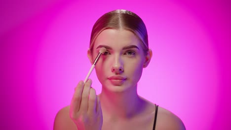 caucasian lady makeup herself with skin dusting powder puffs at studio closeup