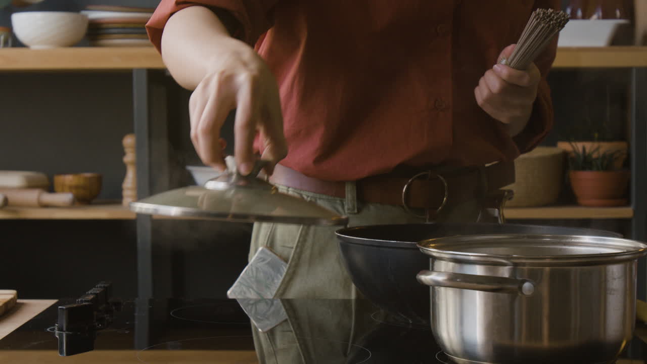 Woman Cooking Noodles in Kitchen