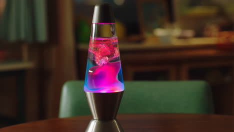 vibrant pink and blue lava lamp on a wooden table
