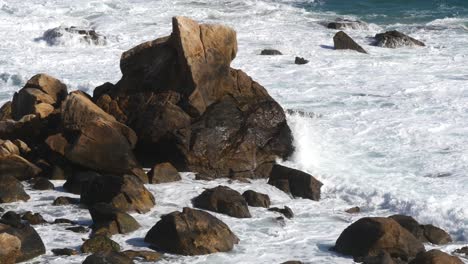 cámara de olas pasando rocas = toma estática de las olas llegando sobre las rocas tomadas desde el melia atlanterra hacia el faro