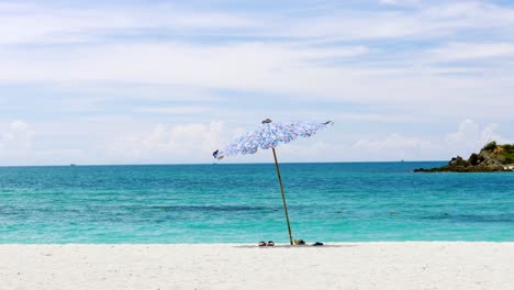 Umbrellas-are-fixed-on-the-beach-near-the-beautiful-blue-sea-and-the-atmosphere-is-good-with-sea-breezes-suitable-for-relaxation