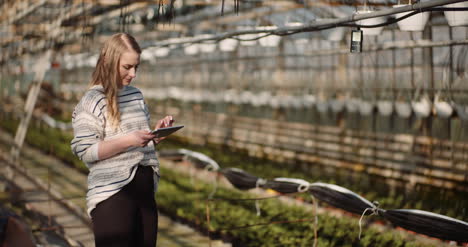 female gardener using digital tablet in greenhouse 7