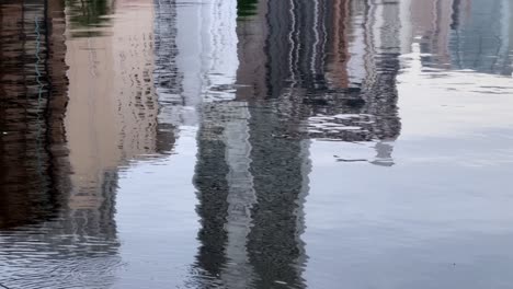 buildings reflected in calm water creating a wavy, abstract image with a serene atmosphere