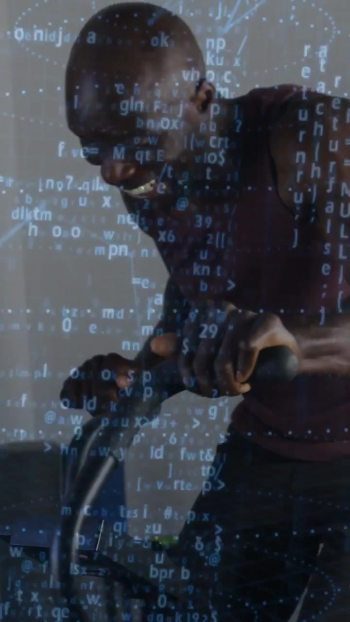 Vertical video: Mature man gripping bike, cycling for stamina in gym, with scrolling code overlay