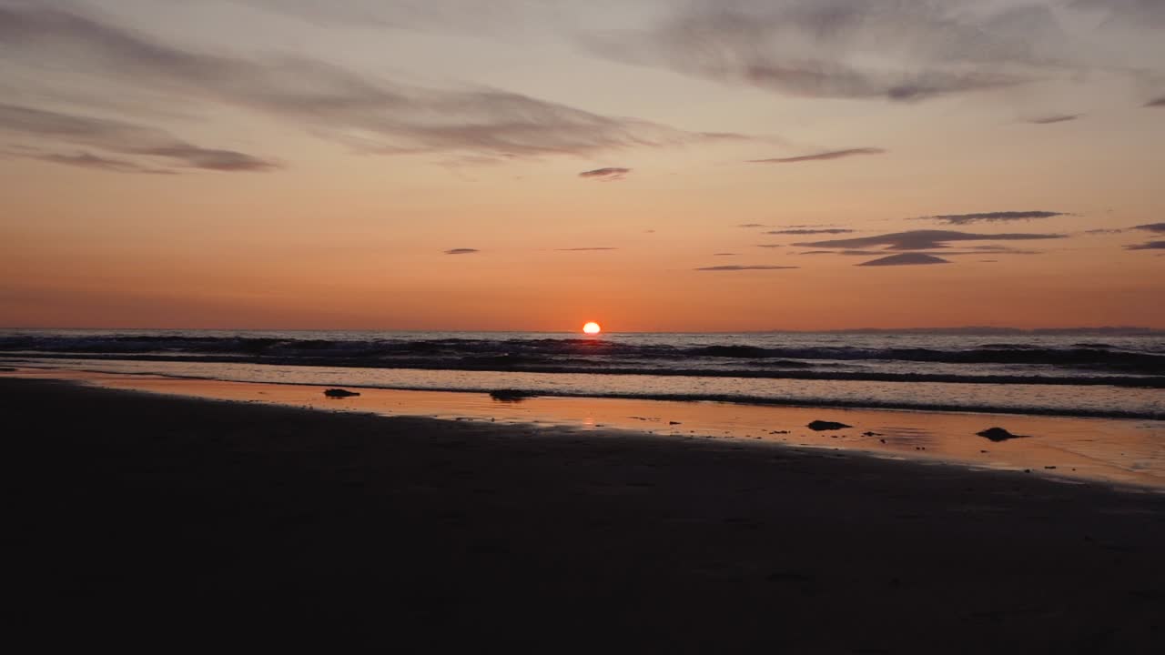 hombre corriendo con guitarra en la playa de arena trasera al atardecer-32