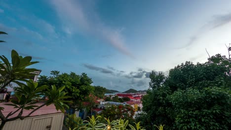 Wispy-clouds-fly-past-historic-rooftops-in-downtown-Charlotte-Amalie-as-sunset-fades-into-nightfall---Timelapse