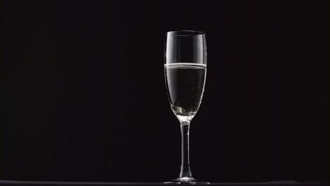 champagne glasses with champagne rotating on a black background champagne glasses with champagne rotating on a black background concept celebrating time new years eve valentines day