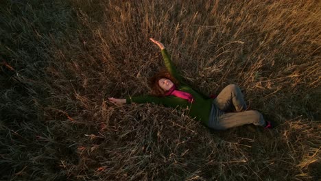 mujer relajándose en un campo al atardecer