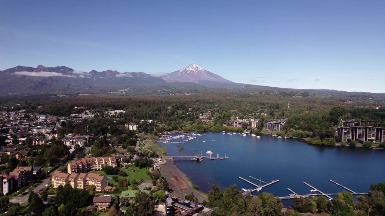 Vista aerea della città di Pucón con il lago visibile e il vulcano sullo sfondo.