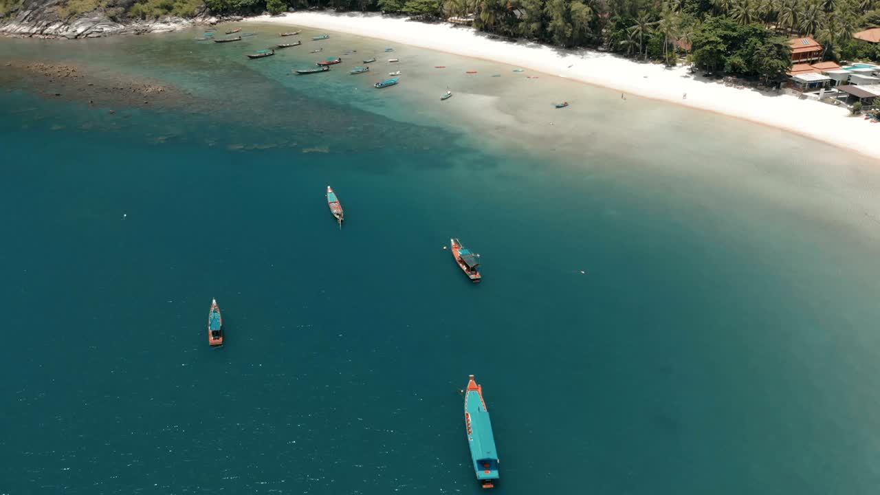flying over amazing white sand beach and tropical lagoon with boats