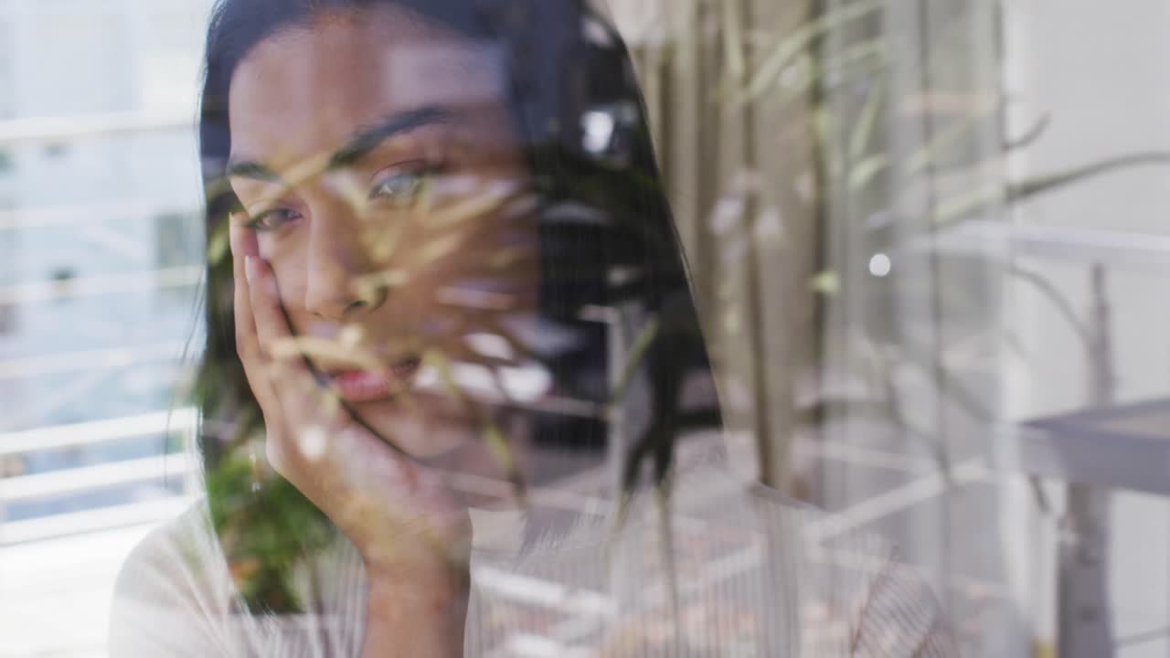 persona de género fluido de raza mixta mirando por la ventana en casa